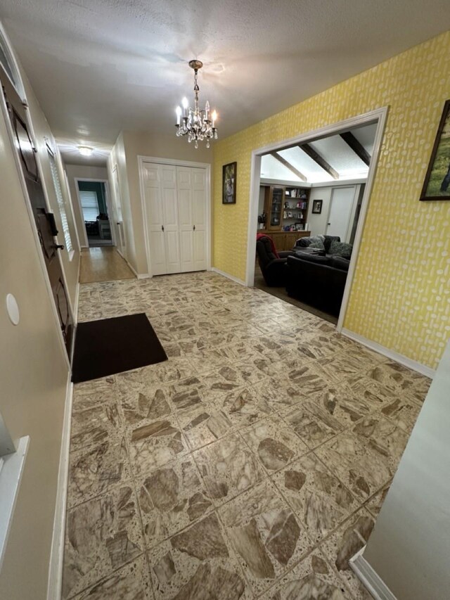 563 12th St, Bay City, TX 77414 - corridor featuring a chandelier, wallpapered walls, baseboards, and a textured ceiling