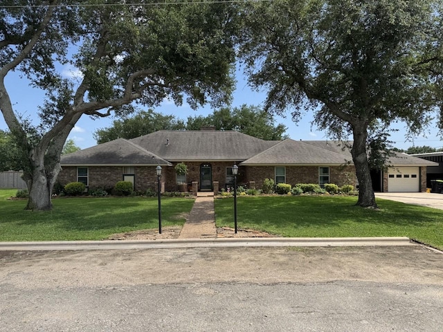 563 12th St, Bay City, TX 77414 - single story home with an attached garage, a front lawn, and brick siding