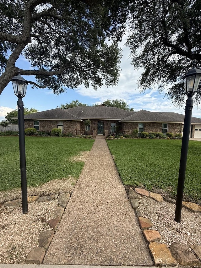 563 12th St, Bay City, TX 77414 - ranch-style home featuring a front lawn and brick siding