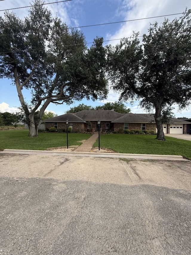 563 12th St, Bay City, TX 77414 - single story home featuring a front yard, brick siding, and a garage