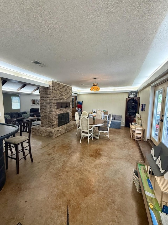 563 12th St, Bay City, TX 77414 - dining room with a textured ceiling, a fireplace, and finished concrete floors
