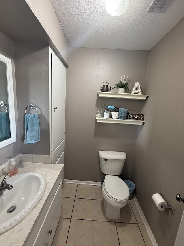 563 12th St, Bay City, TX 77414 - half bath with toilet, vanity, a textured ceiling, tile patterned flooring, and baseboards