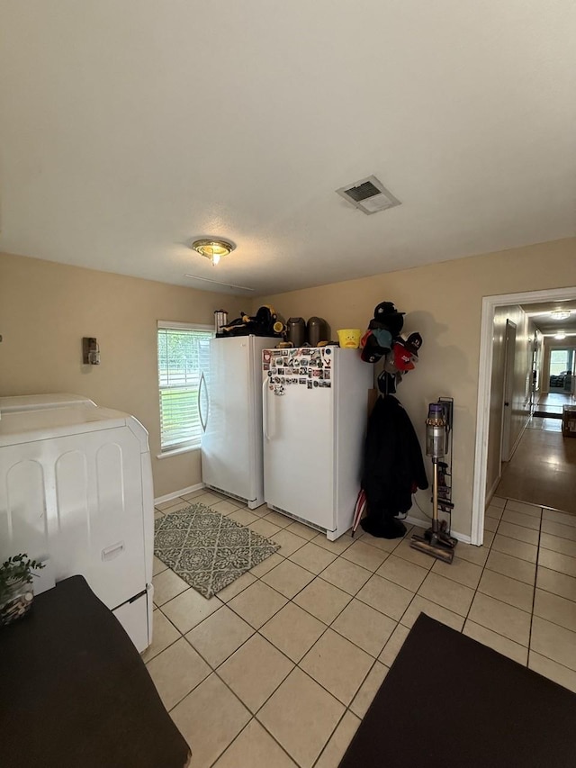 563 12th St, Bay City, TX 77414 - laundry area featuring washer / clothes dryer, light tile patterned flooring, and baseboards