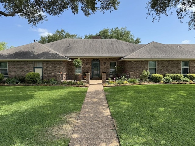 563 12th St, Bay City, TX 77414 - single story home with a shingled roof, a front lawn, and brick siding
