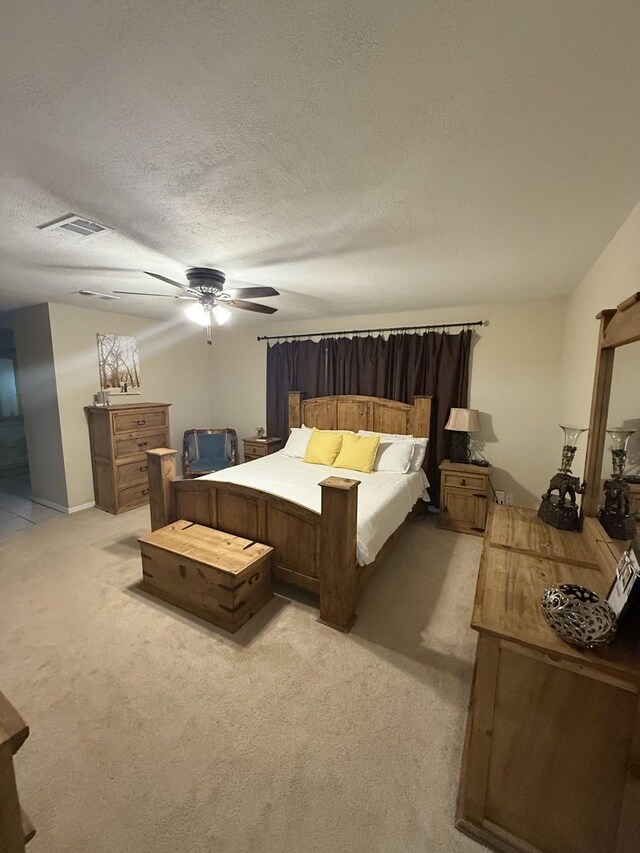 563 12th St, Bay City, TX 77414 - bedroom featuring light carpet, a textured ceiling, and a ceiling fan