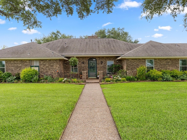 563 12th St, Bay City, TX 77414 - ranch-style home featuring roof with shingles, a front yard, and brick siding
