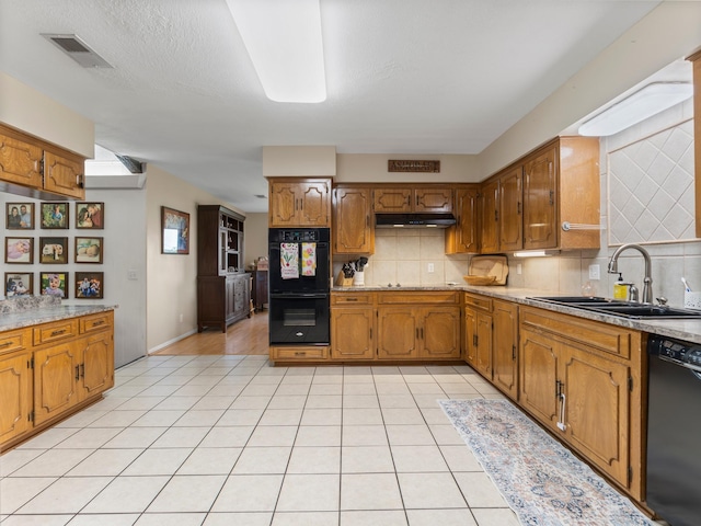 563 12th St, Bay City, TX 77414 - kitchen with black appliances, under cabinet range hood, backsplash, and brown cabinetry