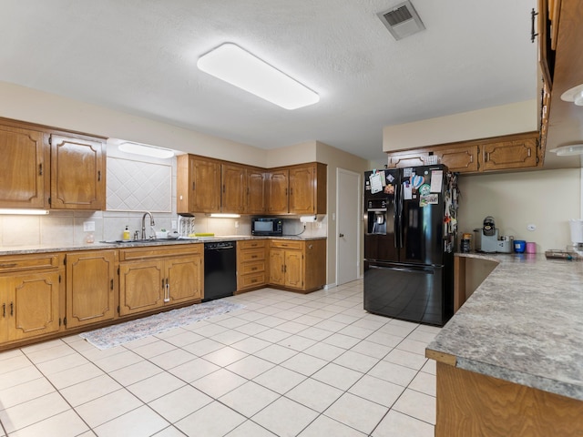 563 12th St, Bay City, TX 77414 - kitchen with black appliances, decorative backsplash, brown cabinets, light countertops, and light tile patterned floors