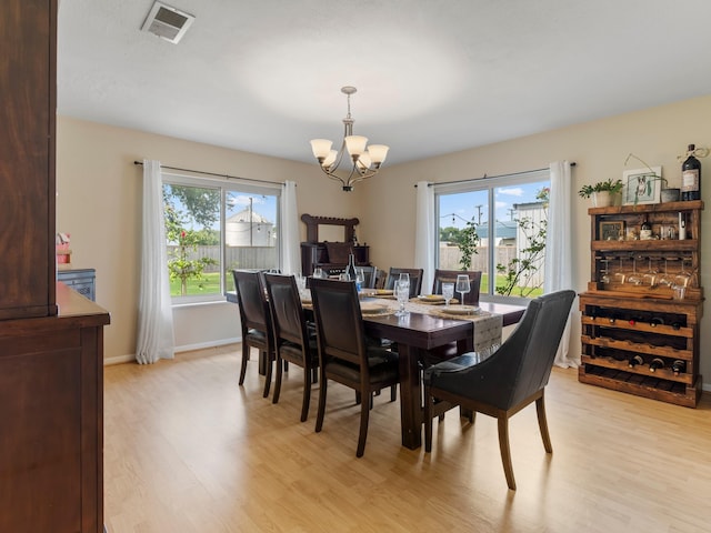 563 12th St, Bay City, TX 77414 - dining space with light wood-type flooring, a chandelier, and healthy amount of natural light
