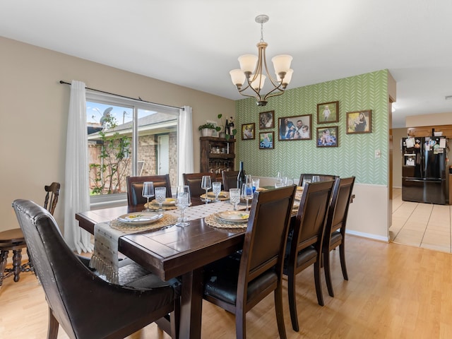563 12th St, Bay City, TX 77414 - dining area featuring a chandelier, an accent wall, wallpapered walls, and light wood finished floors