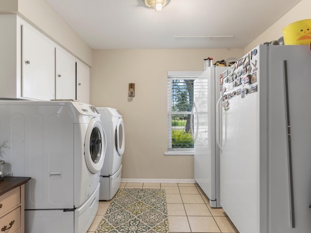 563 12th St, Bay City, TX 77414 - laundry room with light tile patterned floors, washing machine and clothes dryer, and cabinet space