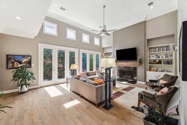 40 E Broad Oaks Dr, Houston, TX 77056 - living room featuring french doors, built in shelves, crown molding, a fireplace, and ceiling fan