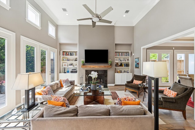 40 E Broad Oaks Dr, Houston, TX 77056 - living room featuring a towering ceiling, built in features, ornamental molding, a premium fireplace, and a ceiling fan
