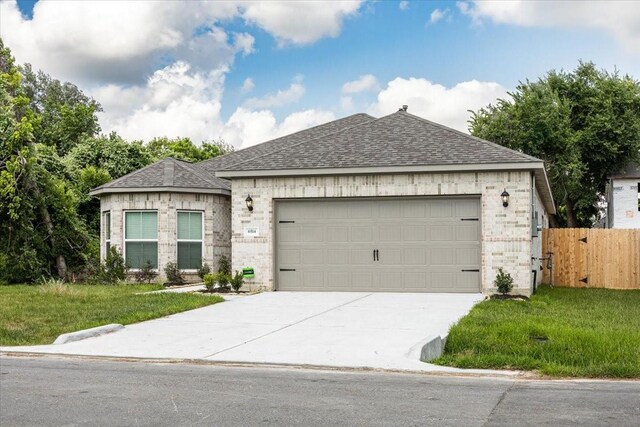 6514 Arabella, Houston, TX 77091 - view of front facade with a shingled roof, concrete driveway, an attached garage, and brick siding