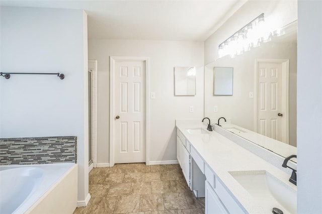 12023 Thornburg Ln, Houston, TX 77067 - full bathroom featuring double vanity, a garden tub, baseboards, a shower with door, and stone finish flooring