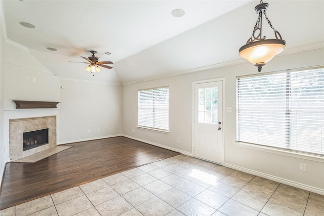 12023 Thornburg Ln, Houston, TX 77067 - unfurnished living room with a ceiling fan, tile patterned flooring, a fireplace, lofted ceiling, and crown molding