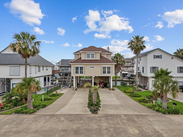 502 Westerly Dr, Tiki Island, TX 77554 - coastal inspired home with a carport, driveway, a residential view, and a shingled roof