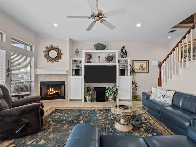 502 Westerly Dr, Tiki Island, TX 77554 - living area featuring a tiled fireplace, crown molding, ceiling fan, recessed lighting, and stairway