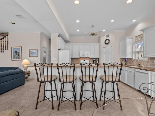 502 Westerly Dr, Tiki Island, TX 77554 - kitchen with white appliances, a sink, a kitchen bar, ceiling fan, and recessed lighting