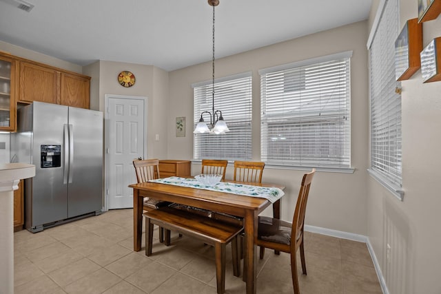 2615 Crystal Falls Dr, Pearland, TX 77584 - dining area with a chandelier, light tile patterned flooring, and baseboards