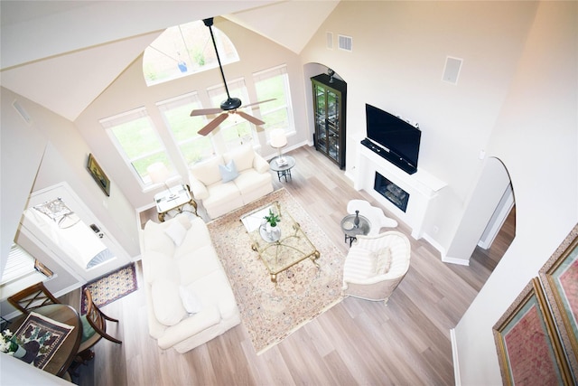 5810 Brook Bend Dr, Sugar Land, TX 77479 - living room with wood finished floors, high vaulted ceiling, a fireplace, arched walkways, and ceiling fan