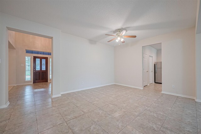 2938 Intrepid Elm St, Houston, TX 77084 - unfurnished room with ceiling fan, light tile patterned flooring, a textured ceiling, and baseboards