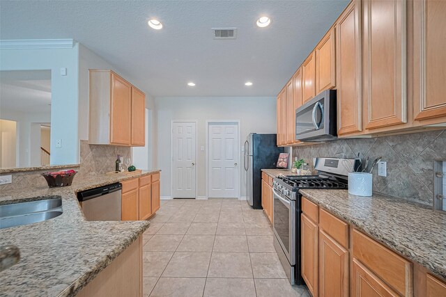 2938 Intrepid Elm St, Houston, TX 77084 - kitchen featuring stainless steel appliances, light stone counters, backsplash, light tile patterned floors, and recessed lighting