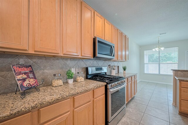 2938 Intrepid Elm St, Houston, TX 77084 - kitchen featuring appliances with stainless steel finishes, baseboards, tasteful backsplash, a chandelier, and light tile patterned floors