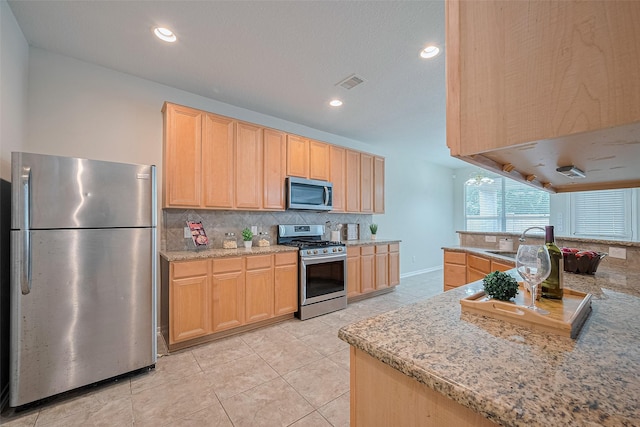 2938 Intrepid Elm St, Houston, TX 77084 - kitchen with appliances with stainless steel finishes, light brown cabinets, backsplash, a sink, and light tile patterned floors