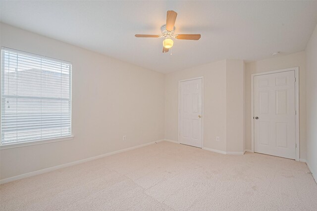 2938 Intrepid Elm St, Houston, TX 77084 - unfurnished bedroom with light colored carpet, baseboards, multiple windows, and ceiling fan