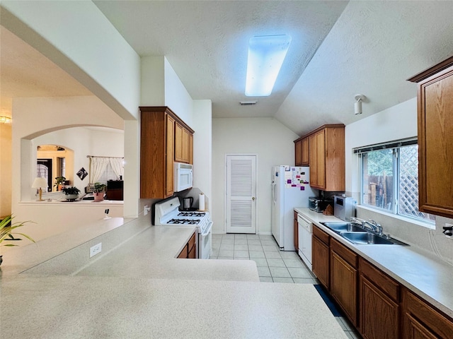 15102 Millers Run Ln, Sugar Land, TX 77498 - kitchen with white appliances, a sink, light countertops, vaulted ceiling, and arched walkways