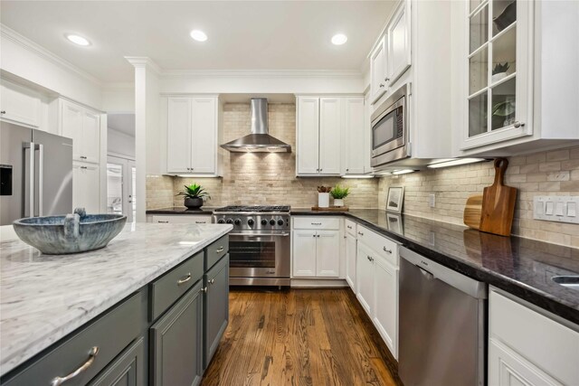 2621 Morrison St, Houston, TX 77009 - kitchen with wall chimney range hood, premium appliances, white cabinets, gray cabinetry, and ornamental molding