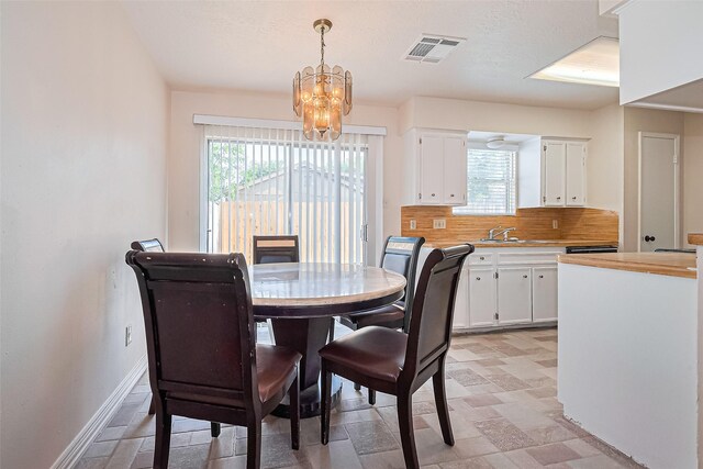13207 Robinglen Dr, Houston, TX 77083 - dining area with a chandelier, plenty of natural light, and baseboards