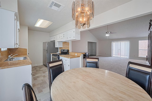 13207 Robinglen Dr, Houston, TX 77083 - kitchen with appliances with stainless steel finishes, a sink, white cabinets, a ceiling fan, and vaulted ceiling