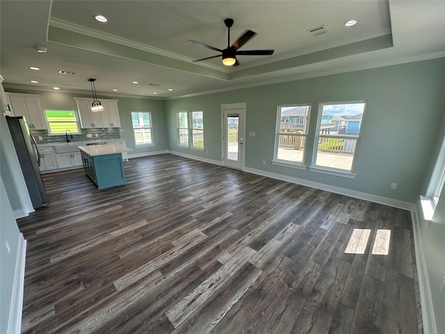 969 Bahama Rd, Crystal Beach, TX 77650 - unfurnished living room with a raised ceiling, dark wood-style flooring, crown molding, a sink, and ceiling fan