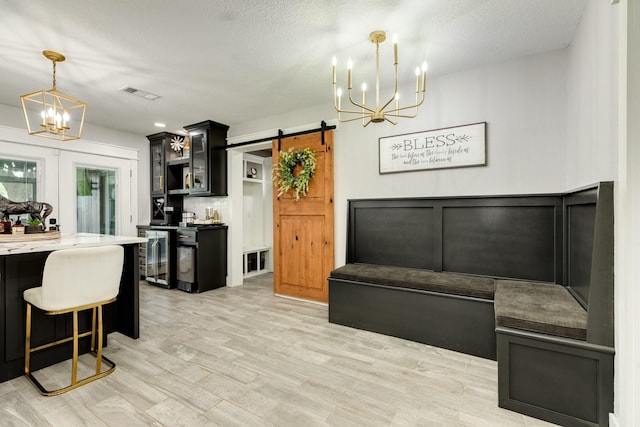 307 County Road 416, Brazoria, TX 77422 - kitchen featuring a chandelier, dark cabinets, a barn door, glass insert cabinets, and a textured ceiling