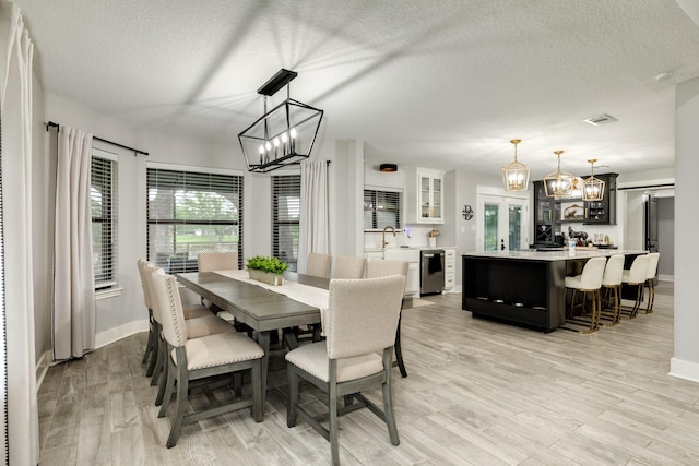 307 County Road 416, Brazoria, TX 77422 - dining space featuring a chandelier, light wood-style floors, a textured ceiling, and baseboards