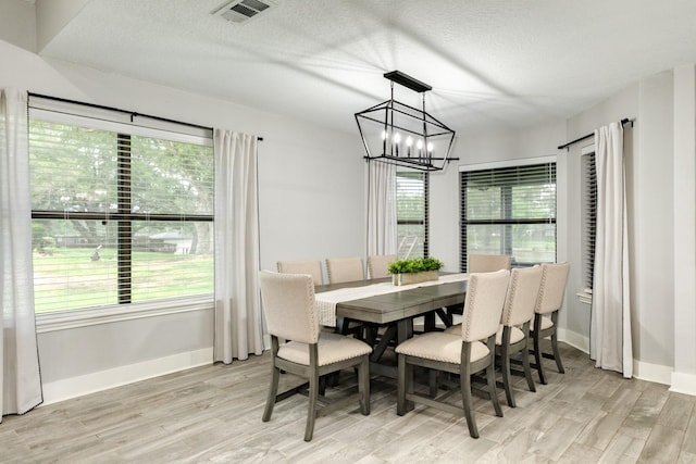 307 County Road 416, Brazoria, TX 77422 - dining room with a chandelier, wood finished floors, plenty of natural light, and a textured ceiling