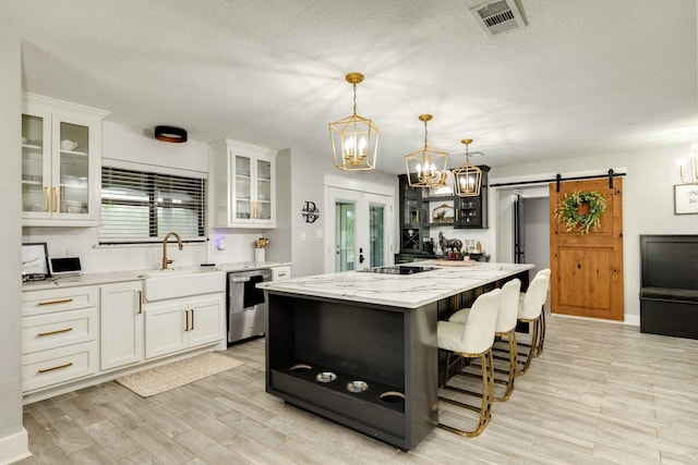 307 County Road 416, Brazoria, TX 77422 - kitchen with dishwasher, a barn door, a sink, a chandelier, and white cabinetry