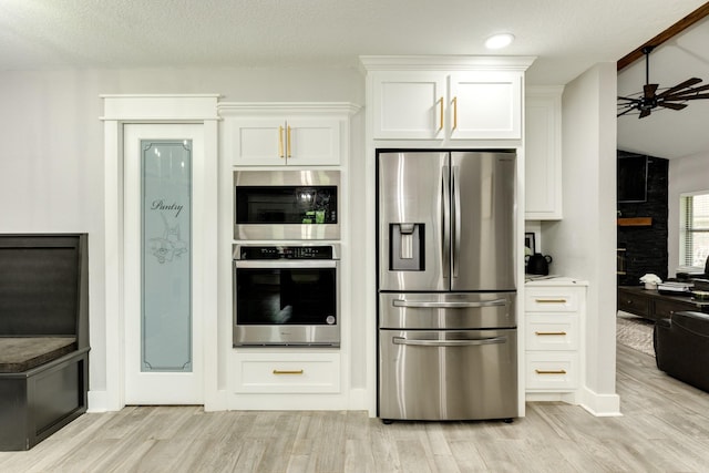 307 County Road 416, Brazoria, TX 77422 - kitchen with stainless steel appliances, white cabinets, ceiling fan, and light wood finished floors