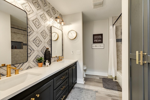 307 County Road 416, Brazoria, TX 77422 - full bath with double vanity, toilet, wood finished floors, shower / bathtub combination with curtain, and baseboards