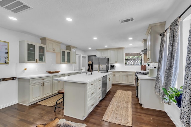 1710 Hill Top Ln, Houston, TX 77339 - kitchen with stainless steel appliances, a sink, a center island with sink, light countertops, and glass insert cabinets