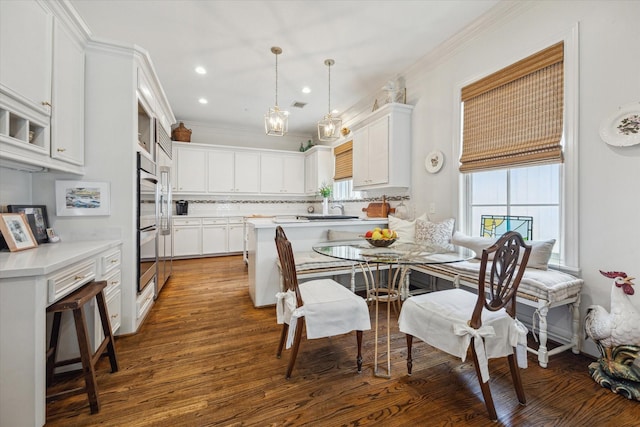 1216 Potomac Dr, Houston, TX 77057 - kitchen with dark wood-style flooring, light countertops, white cabinetry, backsplash, and ornamental molding
