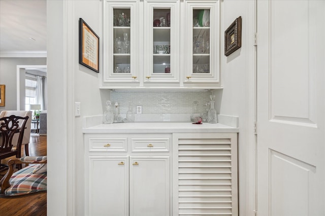 1216 Potomac Dr, Houston, TX 77057 - indoor dry bar featuring crown molding, decorative backsplash, and dark wood finished floors