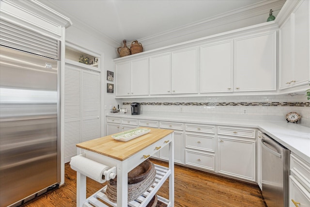 1216 Potomac Dr, Houston, TX 77057 - kitchen with appliances with stainless steel finishes, backsplash, light countertops, white cabinets, and ornamental molding