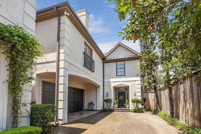 1216 Potomac Dr, Houston, TX 77057 - view of front facade with an attached garage, stucco siding, a chimney, and decorative driveway