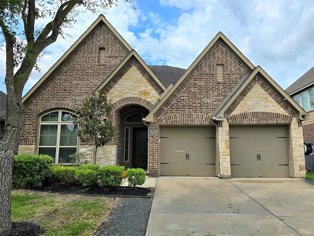 13710 Mooring Pointe Dr, Pearland, TX 77584 - french country inspired facade with stone siding, concrete driveway, a garage, brick siding, and roof with shingles