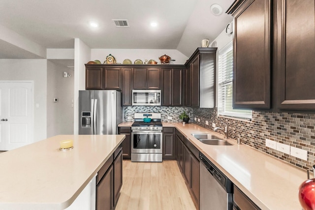 8202 Lockridge Terrace Ln, Cypress, TX 77433 - kitchen with appliances with stainless steel finishes, a sink, dark brown cabinetry, light wood-type flooring, and light countertops