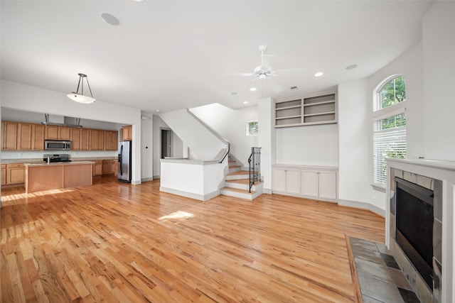 5012 Schuler St, Houston, TX 77007 - unfurnished living room with light wood finished floors, a fireplace, ceiling fan, recessed lighting, and stairway