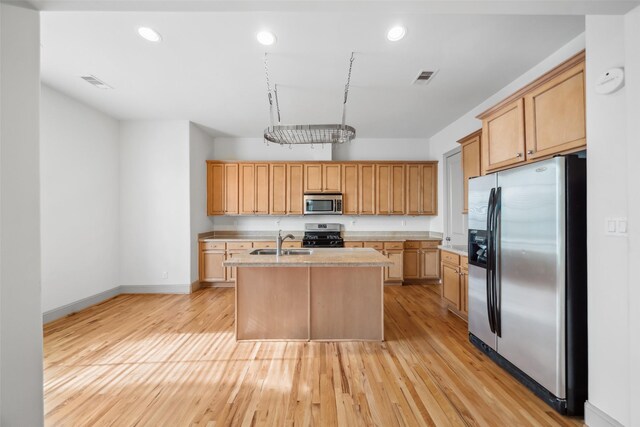 5012 Schuler St, Houston, TX 77007 - kitchen with stainless steel appliances, a sink, light countertops, a kitchen island with sink, and light wood-style flooring